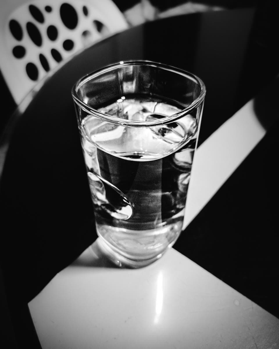 Ein Glas Wasser in einer ruhigen schwarz-weißen Komposition